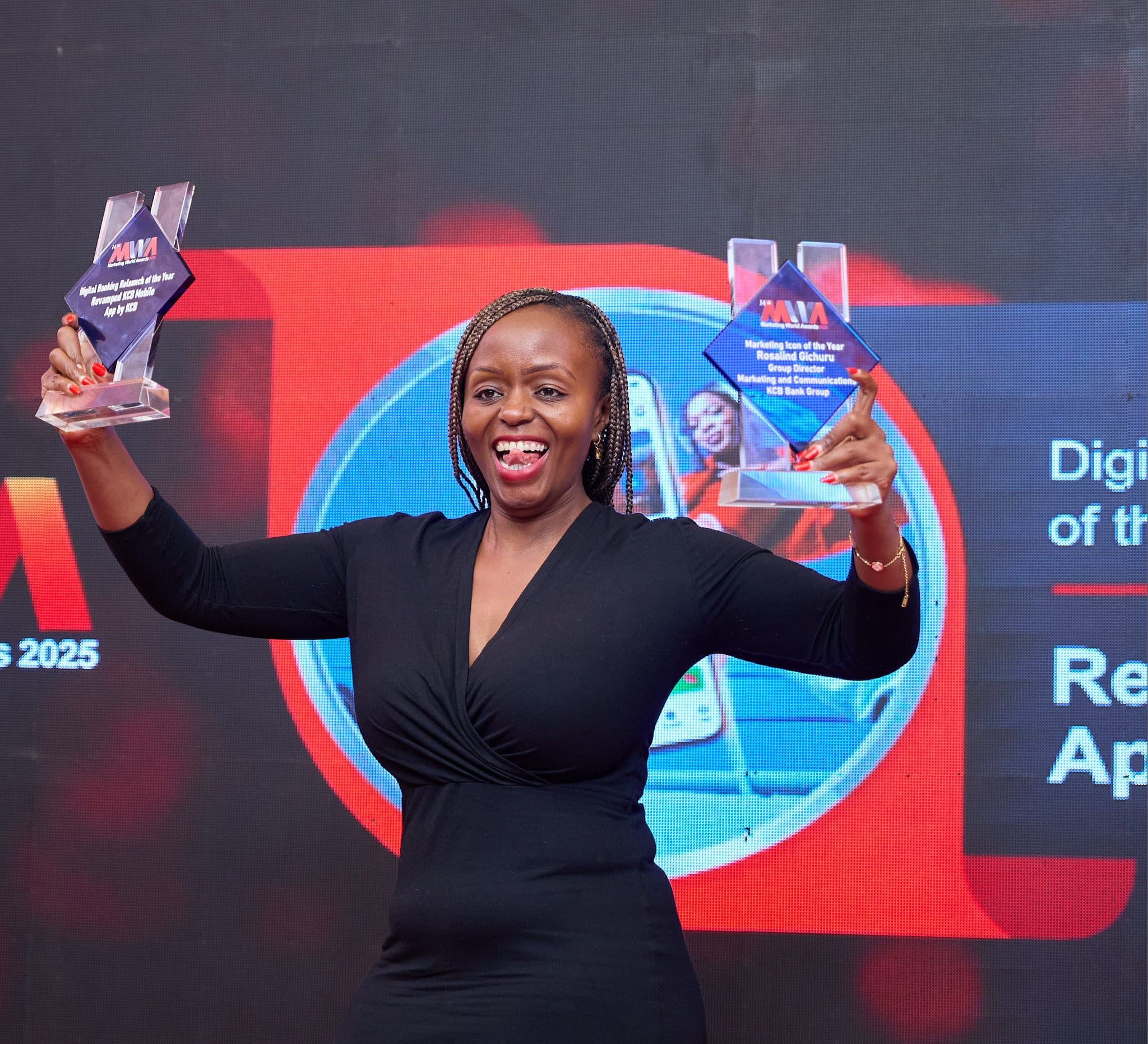 A winner celebrating with two trophies at the Marketing World Awards